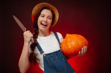 Tulumlu kadın memnuniyetle balkabağından bir feneri bıçakla keser..