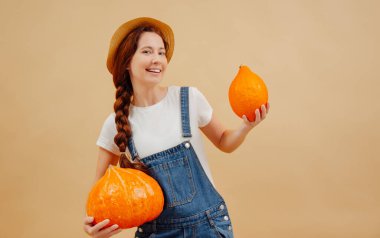 Kot tulumlu çiftçi kadın olgun balkabaklarını güz hasadında tutuyor..