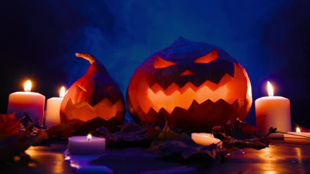 Halloween-Kürbislaternen mit geschnitzten Gesichtern blauer Hintergrund in Rauch. — Stockvideo