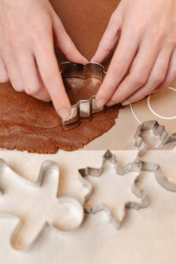 Metal kalıplarla kesilmiş Noel kurabiyeleri için zencefilli ekmek hamuru..