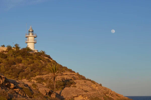 背景に満月のある崖の上の灯台 — ストック写真