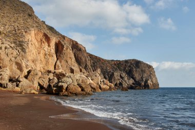 Güneşin doğuşunda uçurumlar arasında terk edilmiş siyah kumsal