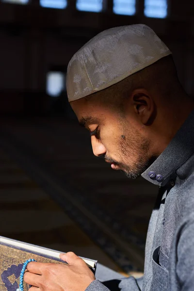 クルアーンを読みながら，若いムスリムの男の顔に太陽が差し込む。 — ストック写真