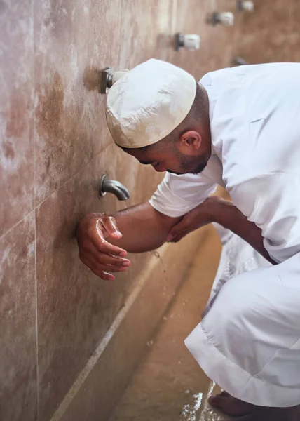 Um homem muçulmano limpando seus braços com água — Fotografia de Stock