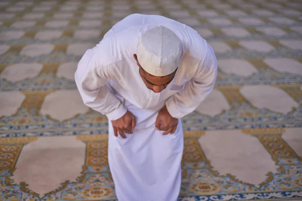 Um homem muçulmano curvando-se durante as orações em uma mesquita — Fotografia de Stock