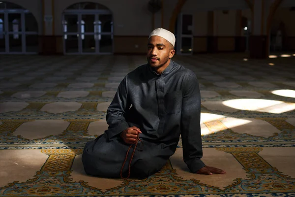 Cândido tiro de macho muçulmano sentado no chão em uma mesquita — Fotografia de Stock