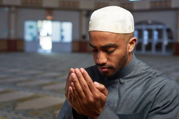 Retrato de um jovem muçulmano fazendo dua e orando em uma mesquita — Fotografia de Stock