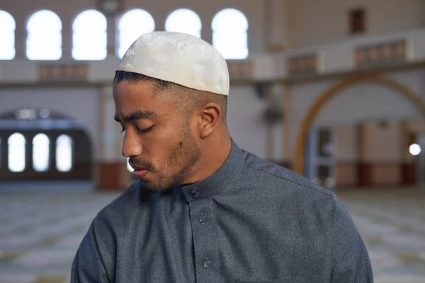 Um homem muçulmano olha por cima de seu ombro direito em oração — Fotografia de Stock