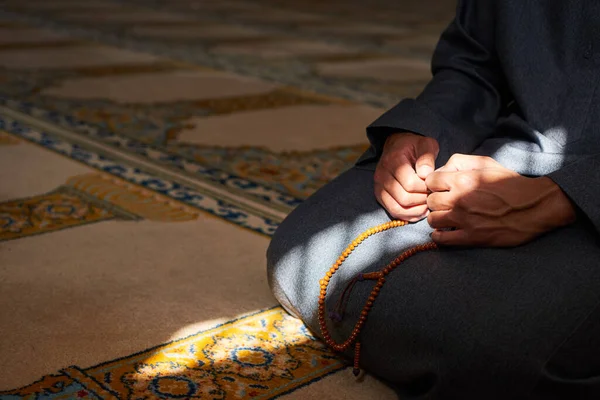 Tutup tangan memegang tasbih di masjid dengan sinar matahari — Stok Foto