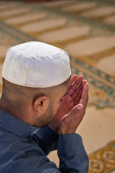 An over the shoulder shot a Muslim man praying with his hands up — Stock Photo, Image