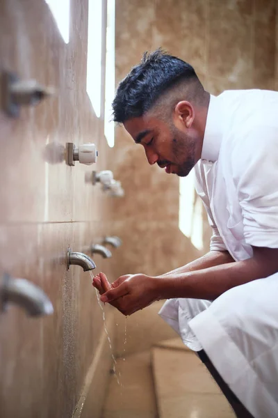 Молодой мусульманин очищает руки в туалете — стоковое фото