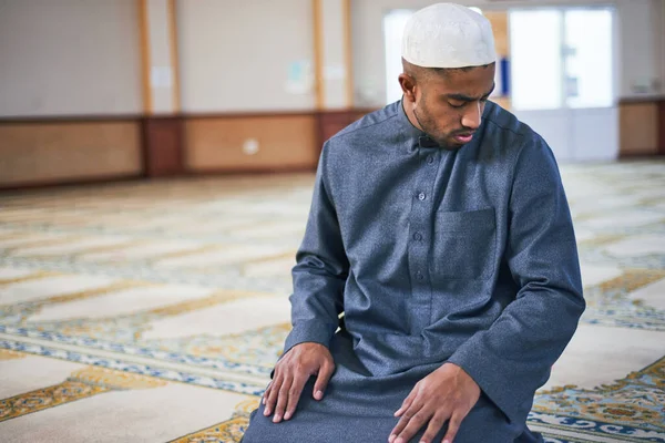 Um homem muçulmano olha por cima de seu ombro esquerdo em oração — Fotografia de Stock