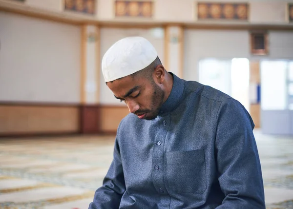 Egy muszlim férfi lehajtja a fejét az imában, miközben egy mecsetben térdel. — Stock Fotó