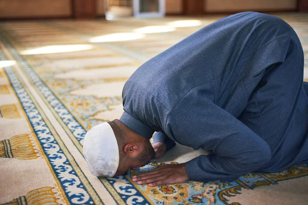 Молодой мусульманин, совершающий намаз в мечети, падает ниц. — стоковое фото