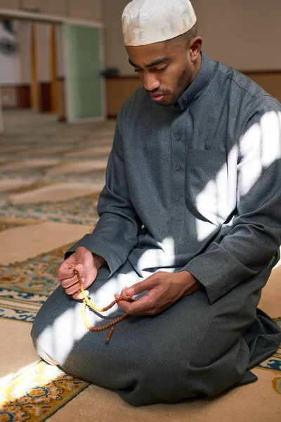 Potret seorang pria berlutut dengan tasbih di sebuah masjid — Stok Foto