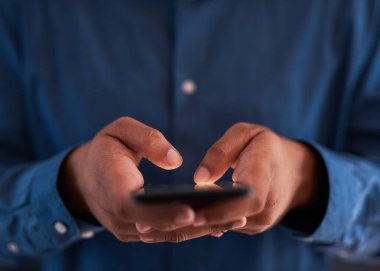 Akıllı bir telefonla yazı yazan bir adamın yakın çekim görüntüsü.
