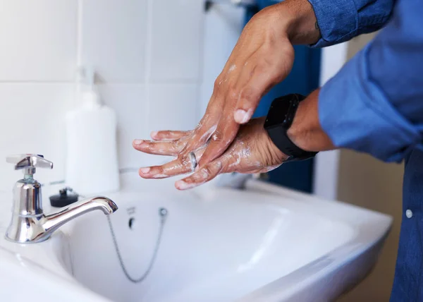 Крупный план бизнесмена, моющего руки в раковине в ванной — стоковое фото