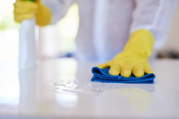 Профессионал по уборке распыляет кухонный счетчик с дезинфицирующим средством — стоковое фото
