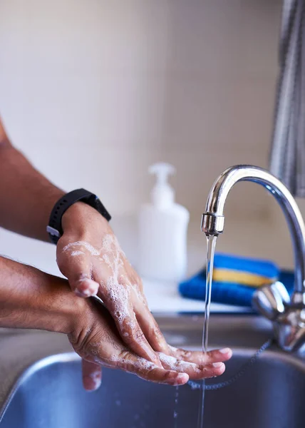 Крупный план взрослого мужчины, моющего руки в кухонной раковине — стоковое фото