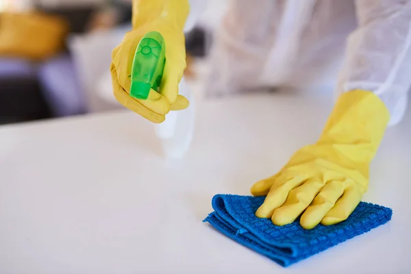 Profesjonalny sprzątacz spryskuje kuchenny blat środkiem czyszczącym — Zdjęcie stockowe