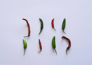 Kırmızı biberli kırmızı biber ve beyaz arka planda yeşil biber. Üst Görünüm düzlüğü