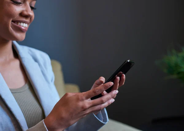 Un primer plano de las manos de una mujer de negocios sosteniendo un teléfono móvil, fondo oscuro — Foto de Stock