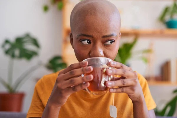 Eine junge Frau nippt an einer Tasse Rooibos oder Rotbuschtee für Gesundheit und Wohlbefinden — Stockfoto