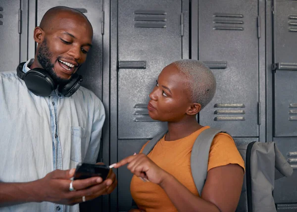 흑인 학생 두 명 이 학교 사물함 앞에서 웃고 핸드폰으로 채팅한다 — 스톡 사진
