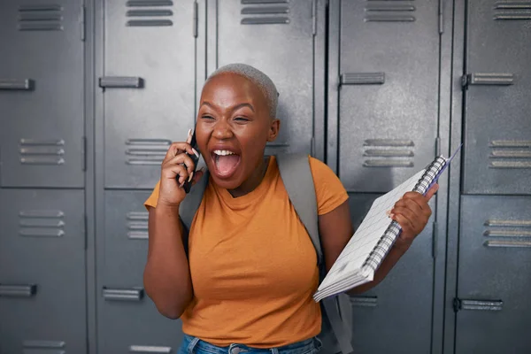 Eine junge Studentin schreit vor Glück am Telefon vor Schließfächern — Stockfoto