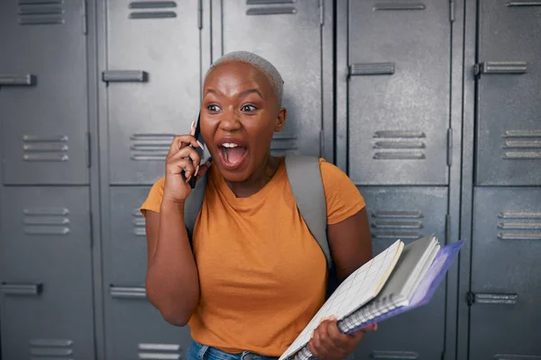 Ein junger schwarzer Student sieht am Telefon vor Schließfächern schockiert und glücklich aus — Stockfoto