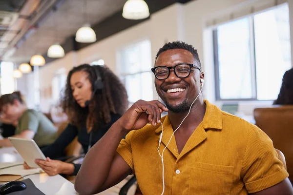 A Black man smiles at the camera wearing glasses in the office — Fotografia de Stock
