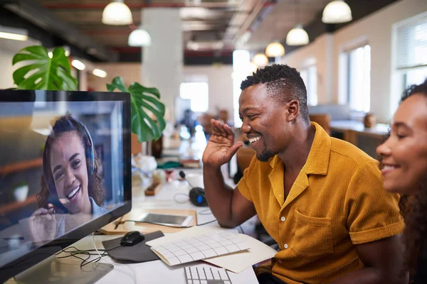 A Black man waves to his colleague on a video call from his office — Fotografia de Stock