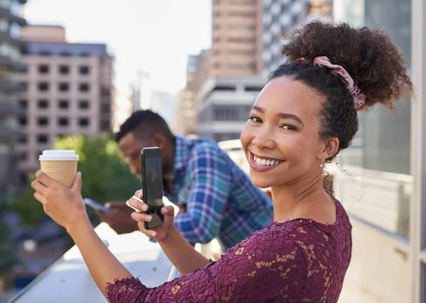 A young woman takes a picture of her coffee on the balcony with the city view — Stockfoto