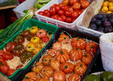 Heirloom tomatoes on sale at a market packaged in straw. High quality photo