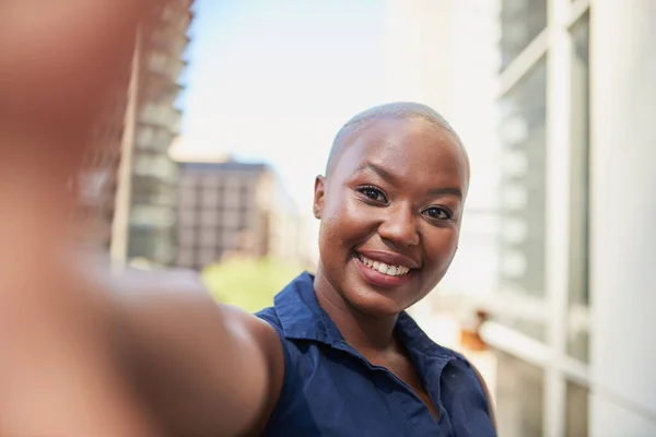 A young Black woman takes a selfie outside the office on the balcony — Stockfoto