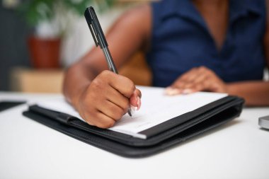 Ofisteki bir kağıda not yazan bir kadının el yazısını kapat.