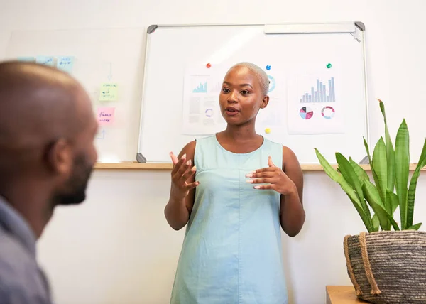 A Black woman explains to coworker during office presentation. High quality photo