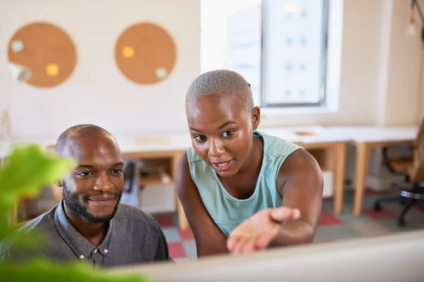 A Black woman gives advice to her colleague in a creative office space. High quality photo