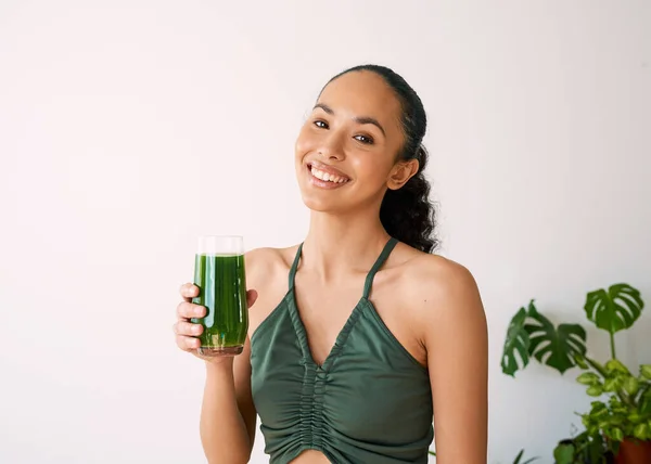 Çok ırklı güzel bir kadın yeşil meyve suyuyla gülümser. Ispanak, lahana, vitaminler. Yüksek kalite fotoğraf