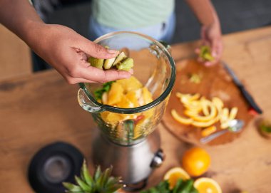Close up overhead shot of hands preparing smoothie in glass blender. High quality photo