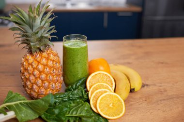 Still life of fruit and freshly made green smoothie on kitchen countertop. High quality photo