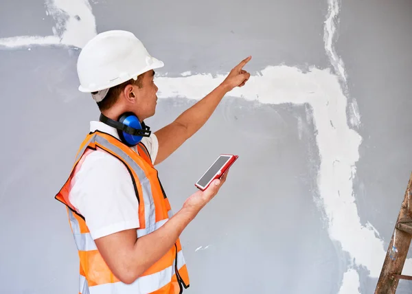 Asian Construction Worker Points Crack Repairs Evaluates Tablet High Quality — Stock Photo, Image