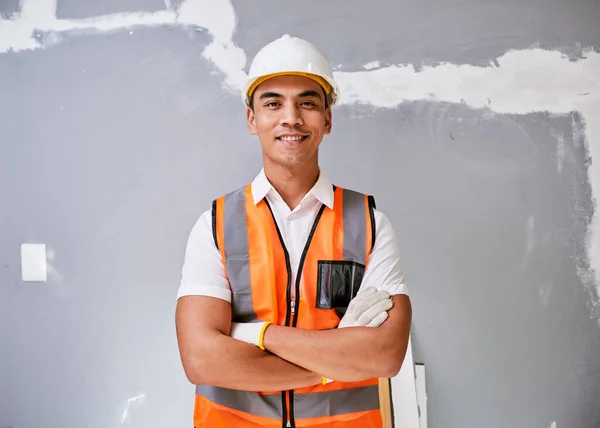 Portrait of a construction worker against cracked and repaired wall smiling. High quality photo