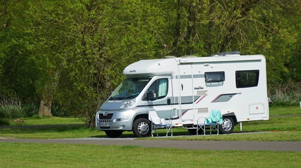 St. NEOTS, CAMBRIDGESHIRE, İngiltere - 18 Nisan 2022: Peugeot Majestic karavanı arka planda ağaçlarla birlikte kamp alanına park edildi.
