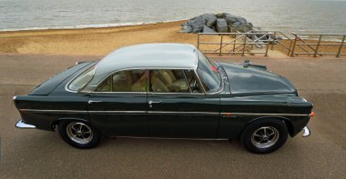 FELIXSTOWE, SUFFOLK, ENGLAND - MAY 01, 2022:  Classic  Blue and White Rover 3.5Litre Car parked on seafront promenade with beach and sea in background.