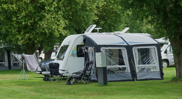St. NEOTS, CAMBRIDGESHIRE, İNGİLTAN - Haziran 03, 2022: Xplore Caravan - Kamp alanındaki ağaçlı tenteli karavan,