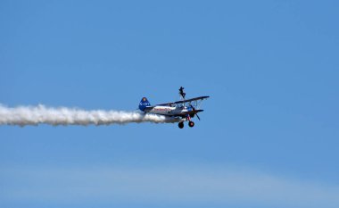 ICKWELL, BEDFORDSHIRE, ENGLAND - AUGUST 07, 2022: Aerosuperbatics wing walking display team aeroplane in flight. Wing walker. 