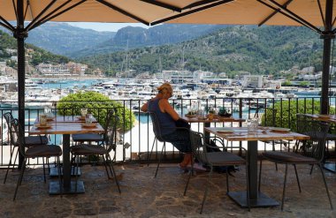SOLLER, MALLORCA, SPAIN - JUNE 16, 2022: Harbour side restaurant with boat and marina in background.