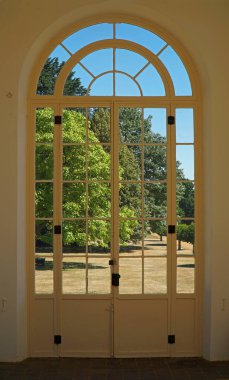 SILSOE, BEDFORDSHIRE, ENGLAND - AUGUST 10, 2022: Looking through Beautiful Arched doorway onto landscaped gardens.