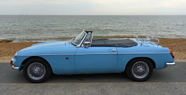 FELIXSTOWE, SUFFOLK, ENGLAND - MAYIS 01, 2022: Arka planda deniz manzaralı deniz kenarında park edilmiş klasik MG Roadster Car.